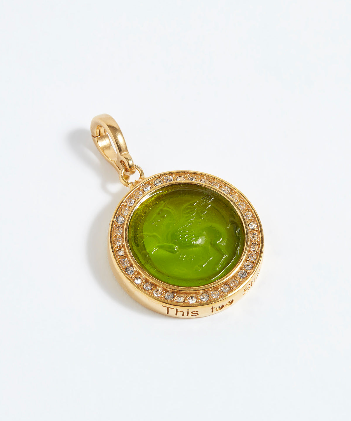 Gold pendant with green stone and '"this too shall pass" engraving on a white background