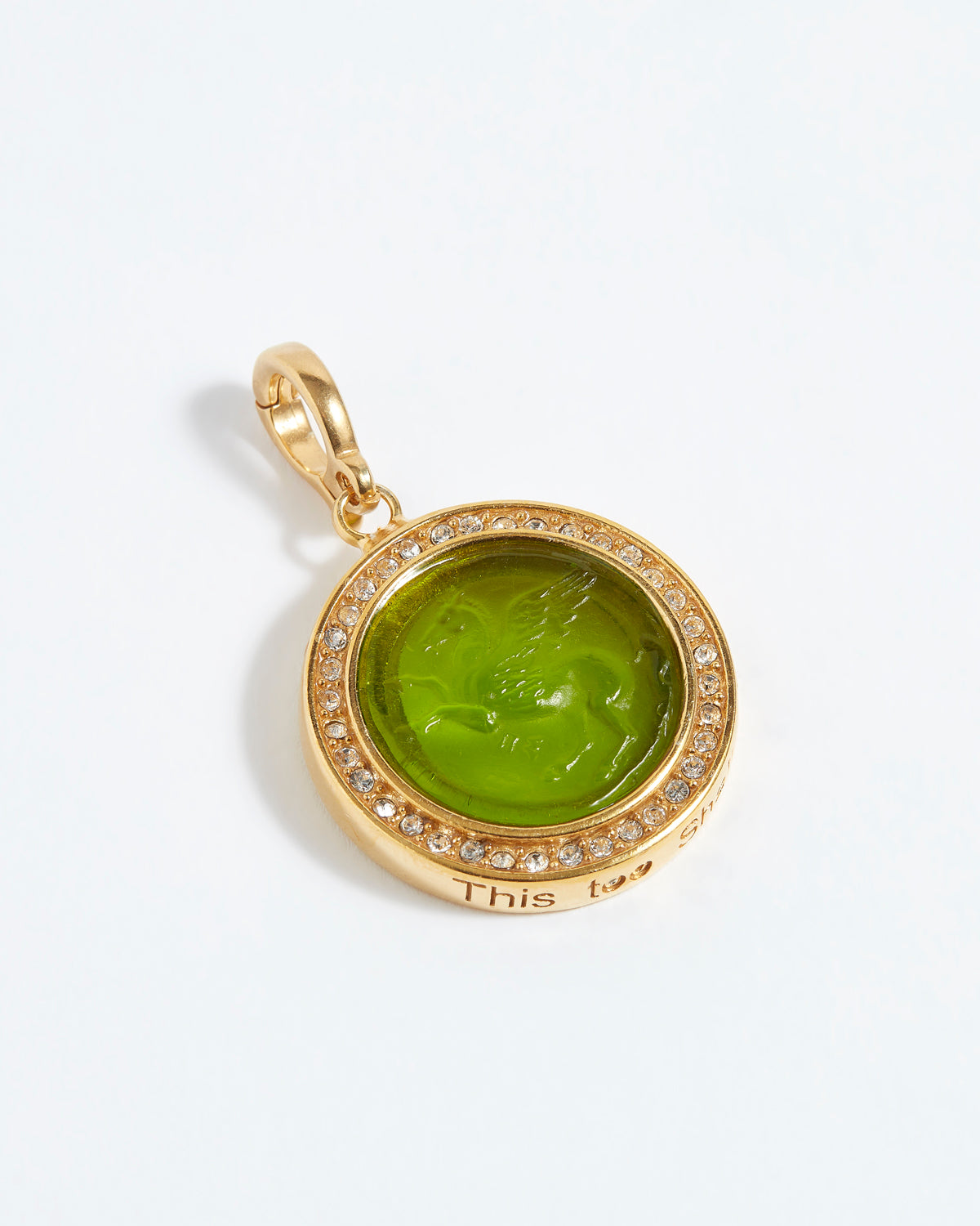 Gold pendant with green stone and '"this too shall pass" engraving on a white background