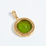 Gold pendant with green stone and '"this too shall pass" engraving on a white background