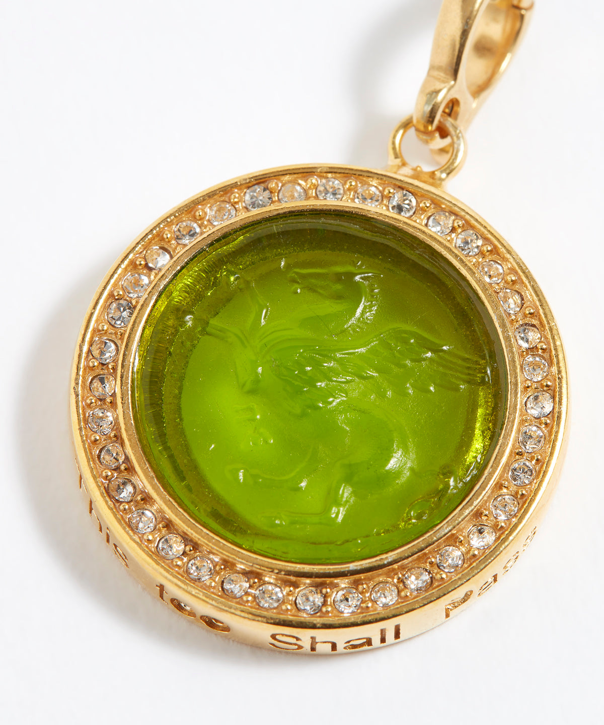 Gold pendant with green gemstone and engraved design "this too shall pass" on a white background