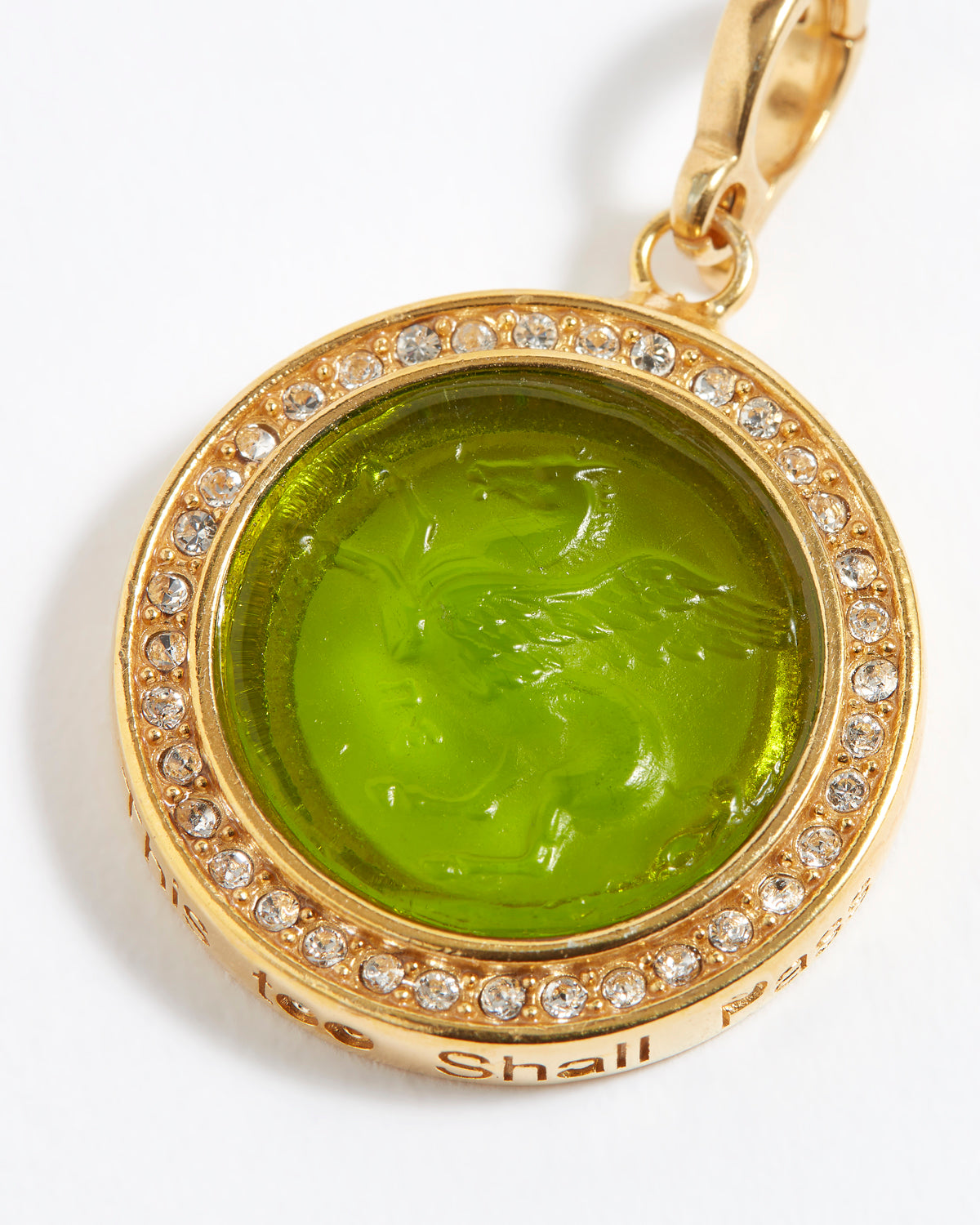Gold pendant with green gemstone and engraved design "this too shall pass" on a white background