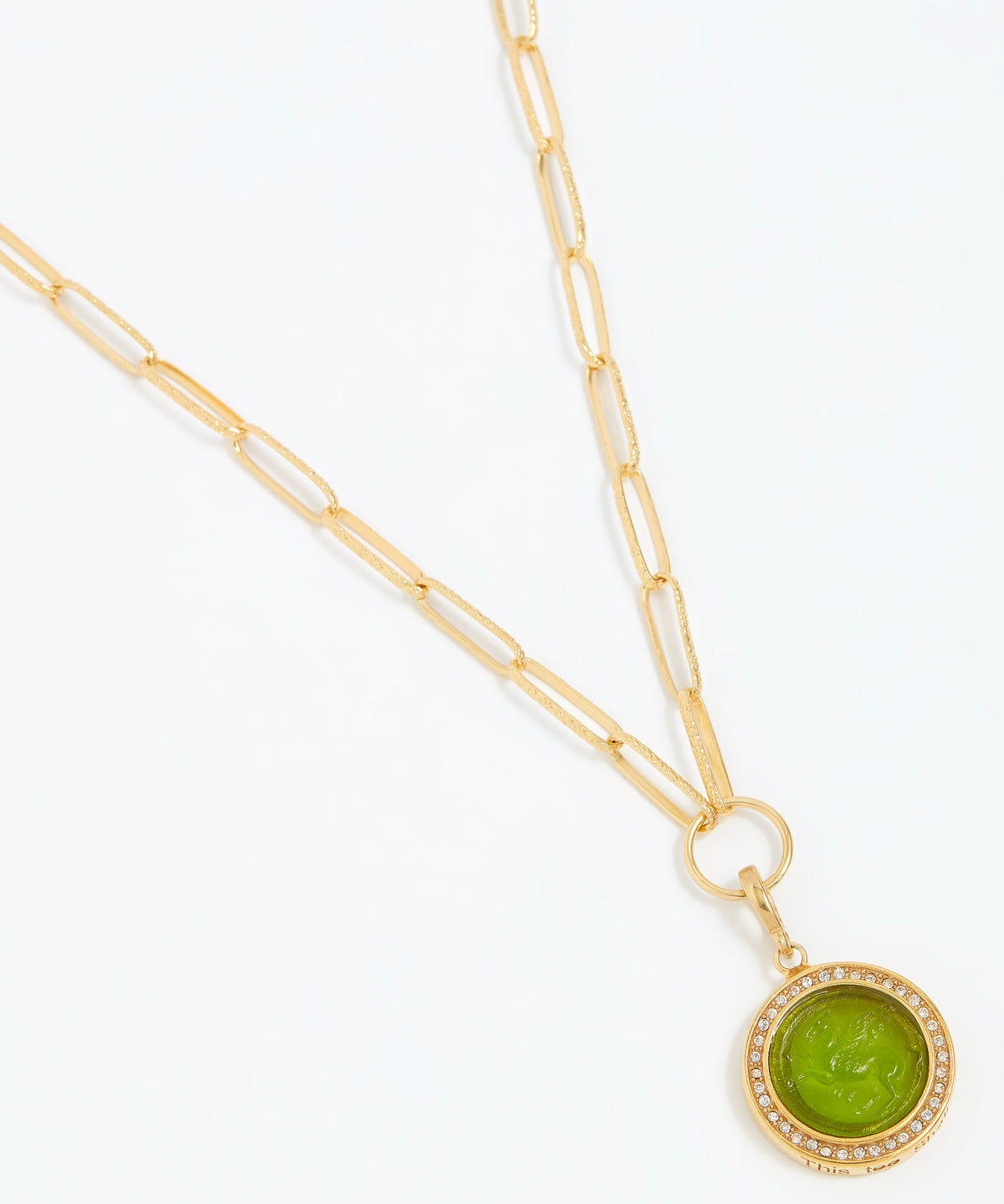 Gold necklace with a green pendant on a white background