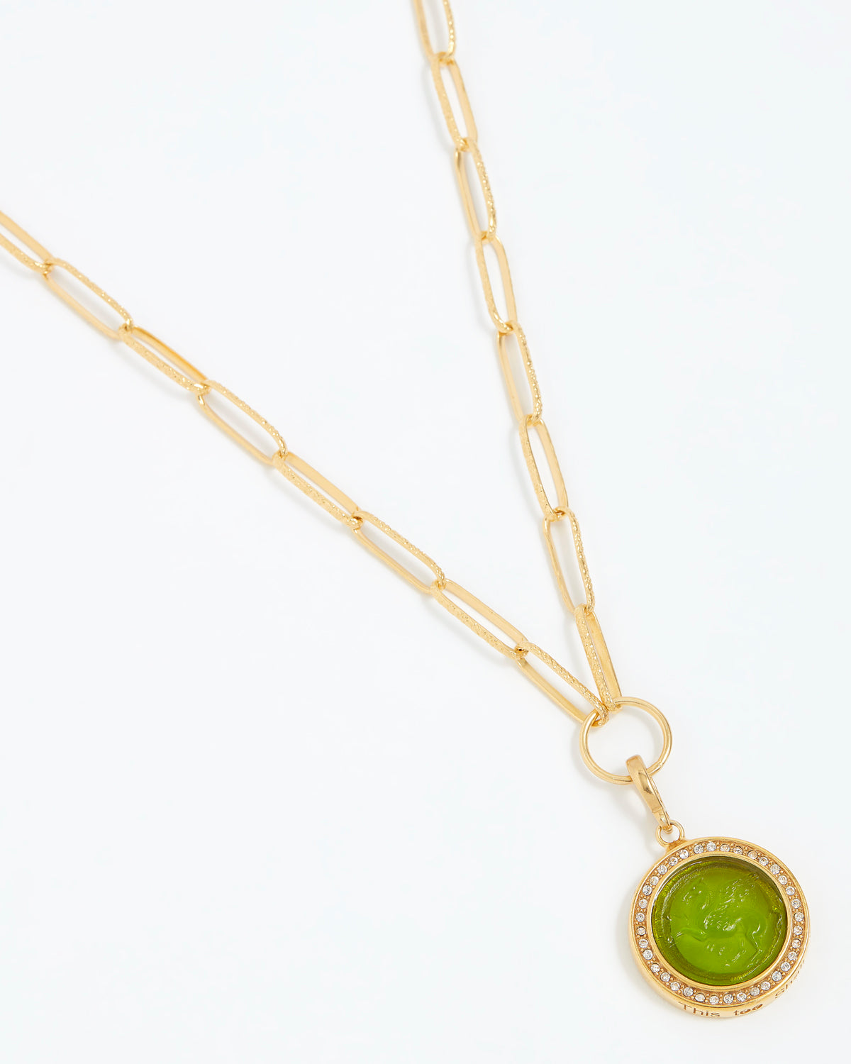 Gold necklace with a green pendant on a white background