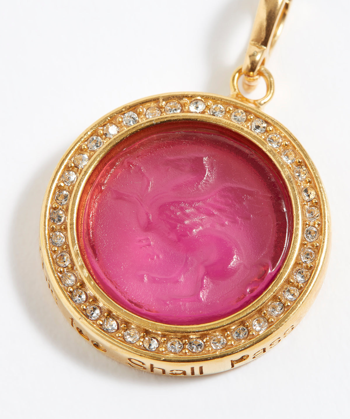Gold pendant with pink gemstone and engraved text "this too shall pass"  on a white background