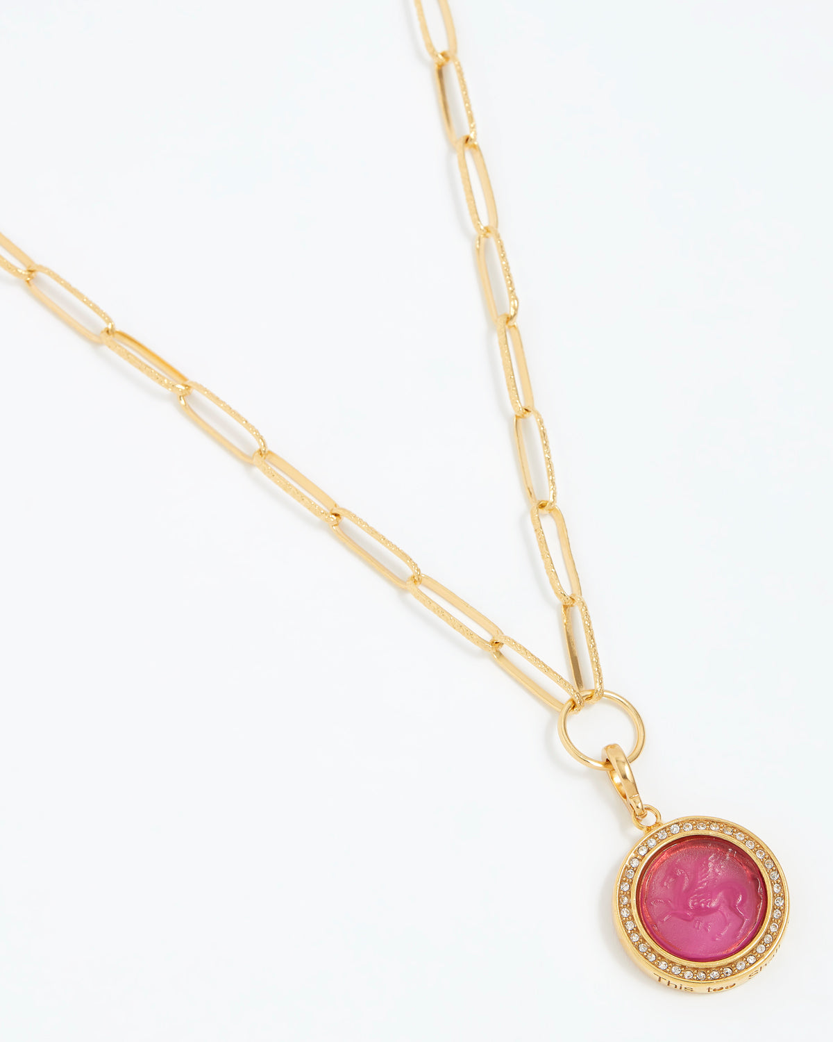 Gold necklace with a pink gemstone pendant on a white background