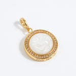 Gold pendant with a white central design on a white background