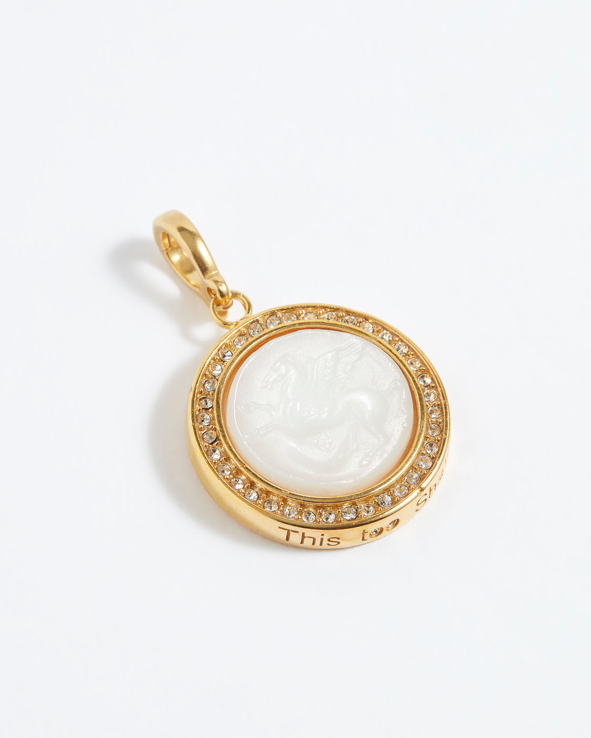 Gold pendant with a white central design on a white background