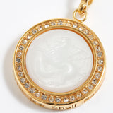 Gold pendant with a white central stone on a white background