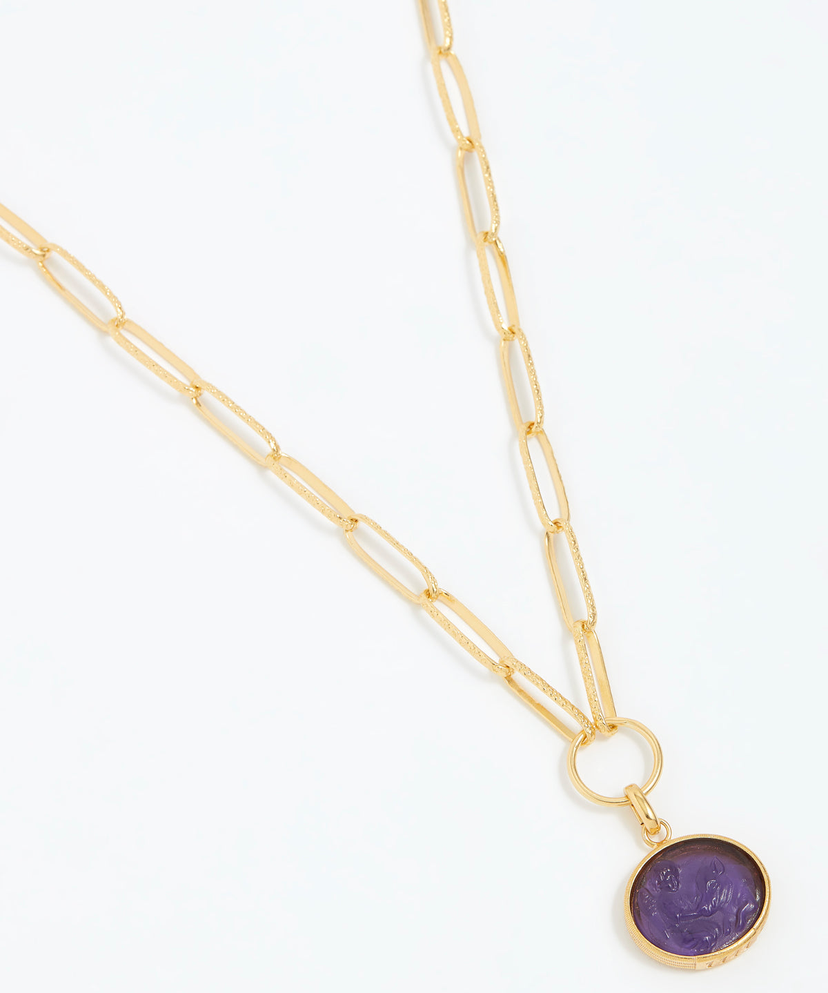 Gold necklace with a purple pendant on a white background