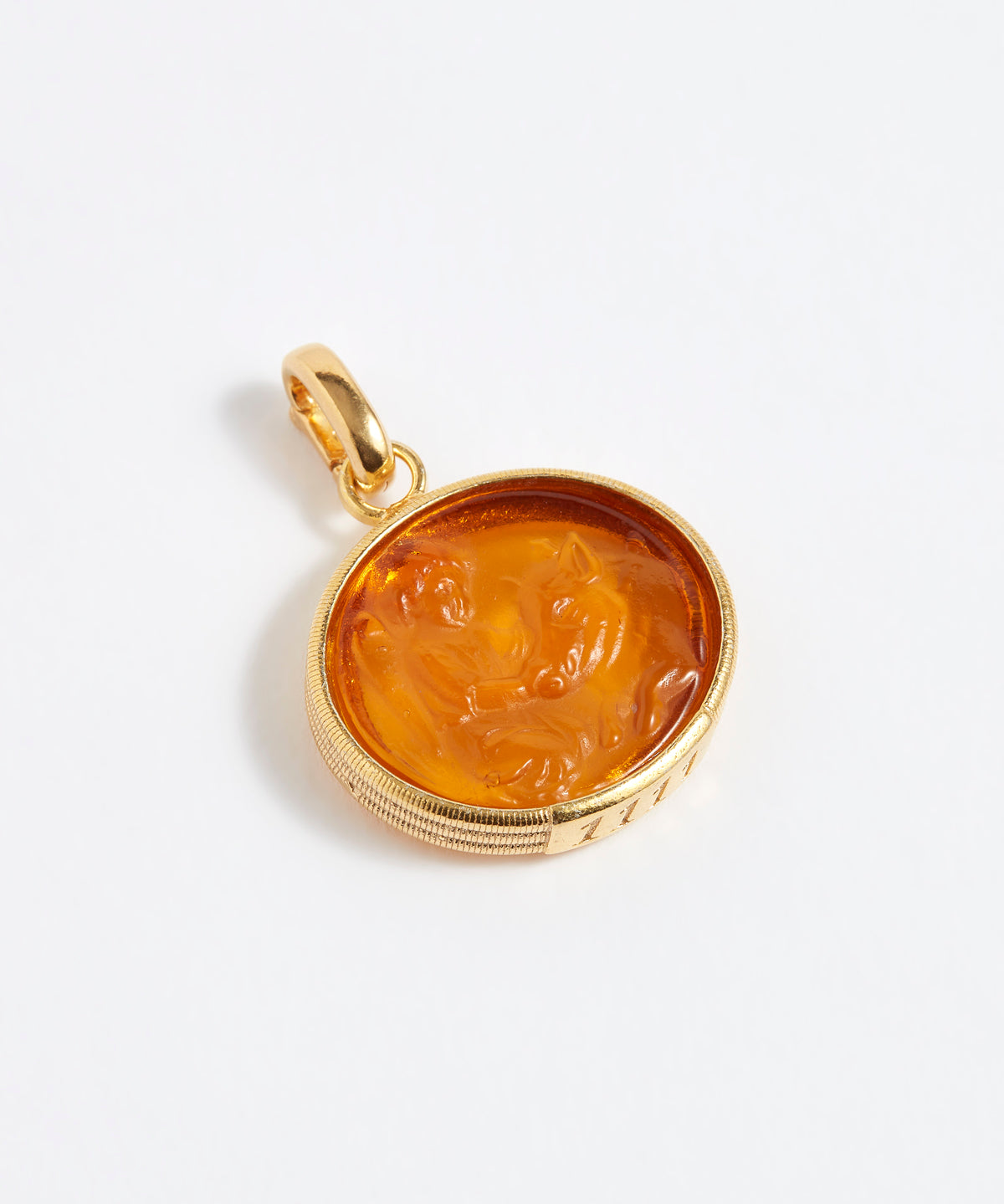 Gold pendant with a face design on a white background