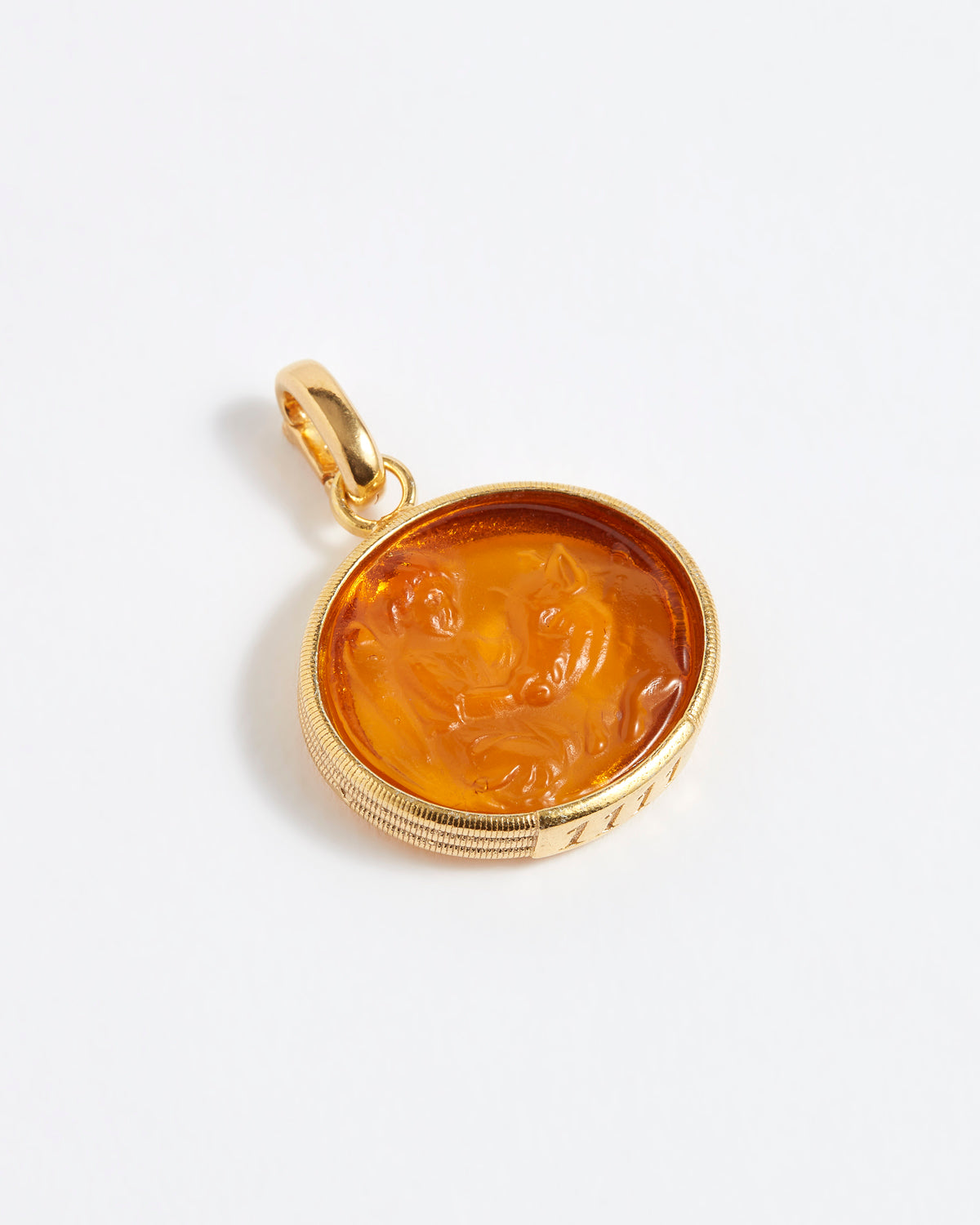 Gold pendant with a face design on a white background