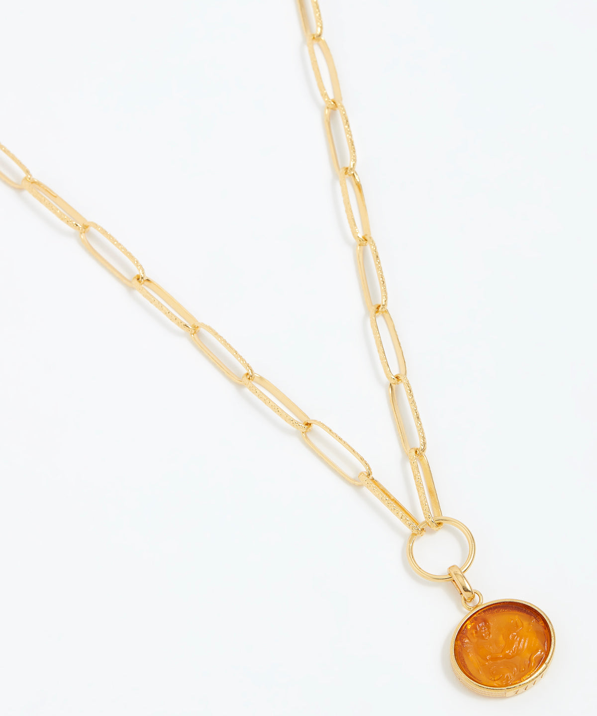 Gold necklace with a circular pendant on a white background