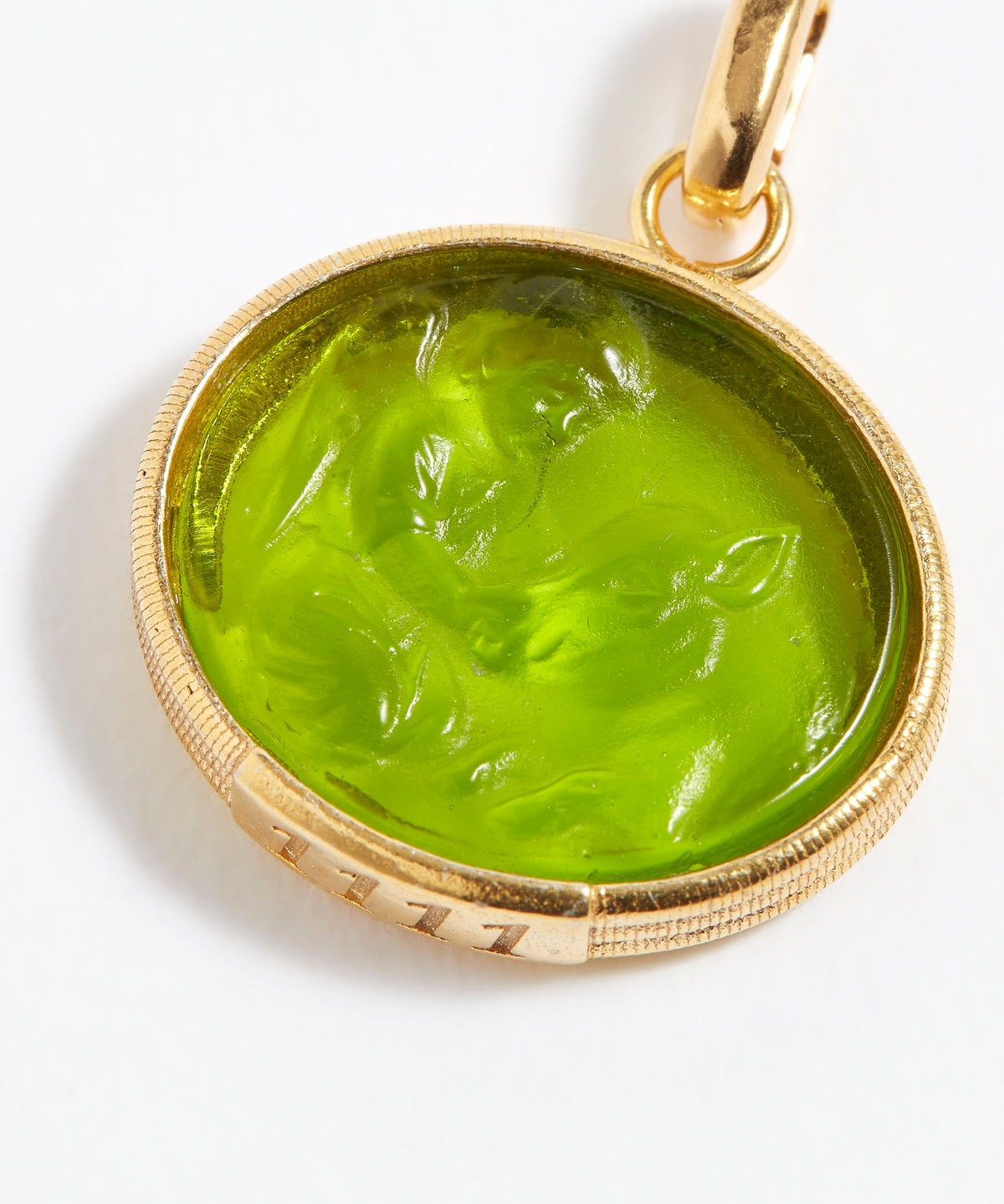 Gold pendant with a green stone on a white background