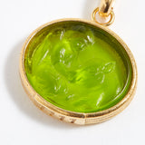 Gold pendant with a green stone on a white background