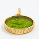 Gold pendant with green stone and engraved angel number '1111' on a white background