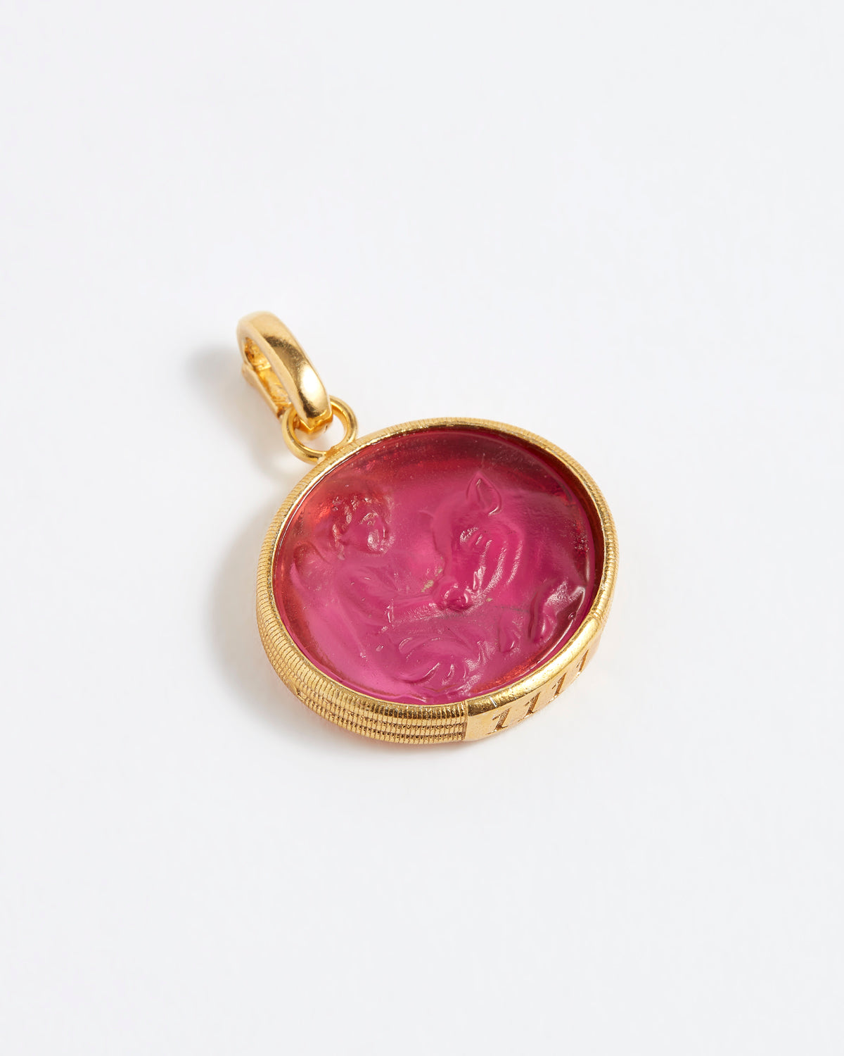 Gold pendant with a pink stone on a white background