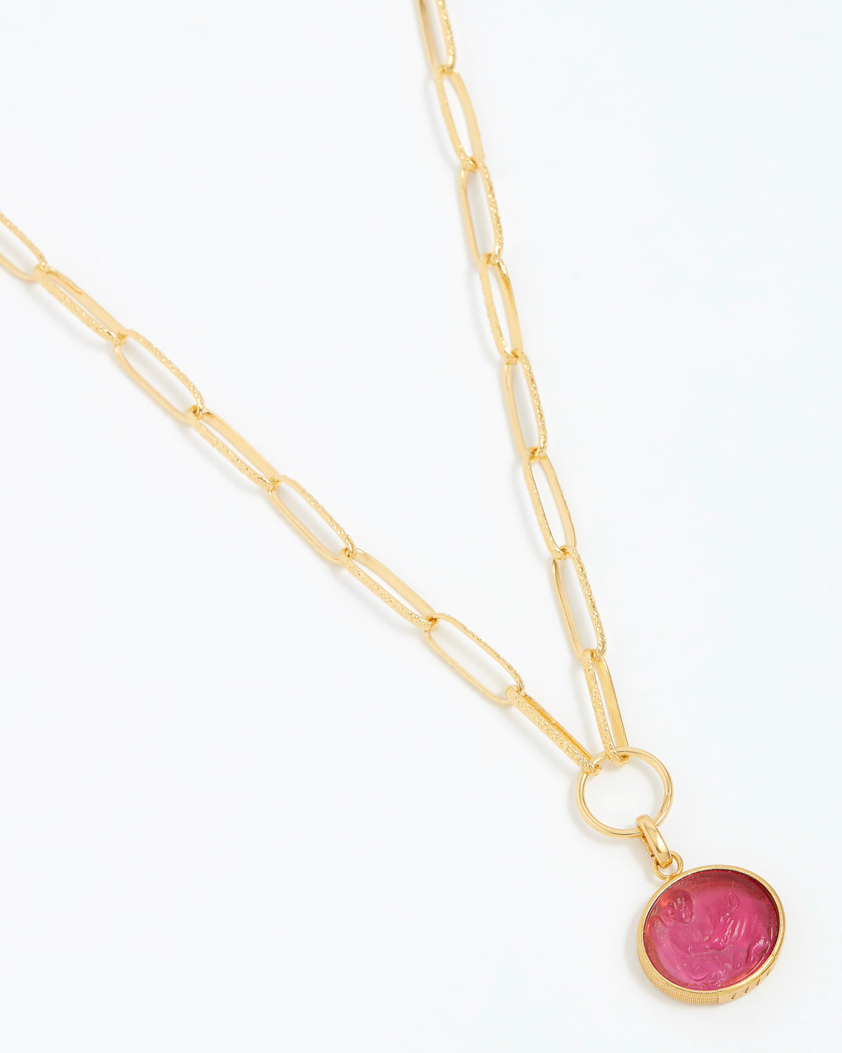 Gold necklace with a pink pendant on a white background