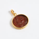 Gold pendant with a topaz circular design on a white background