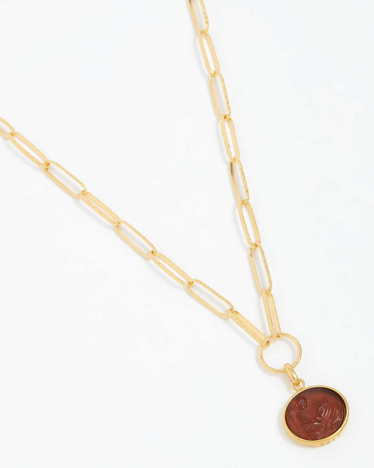 Gold necklace with a round topaz pendant on a white background