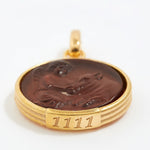 Gold pendant with a topaz stone and engraved angel numbers 1111 on a white background