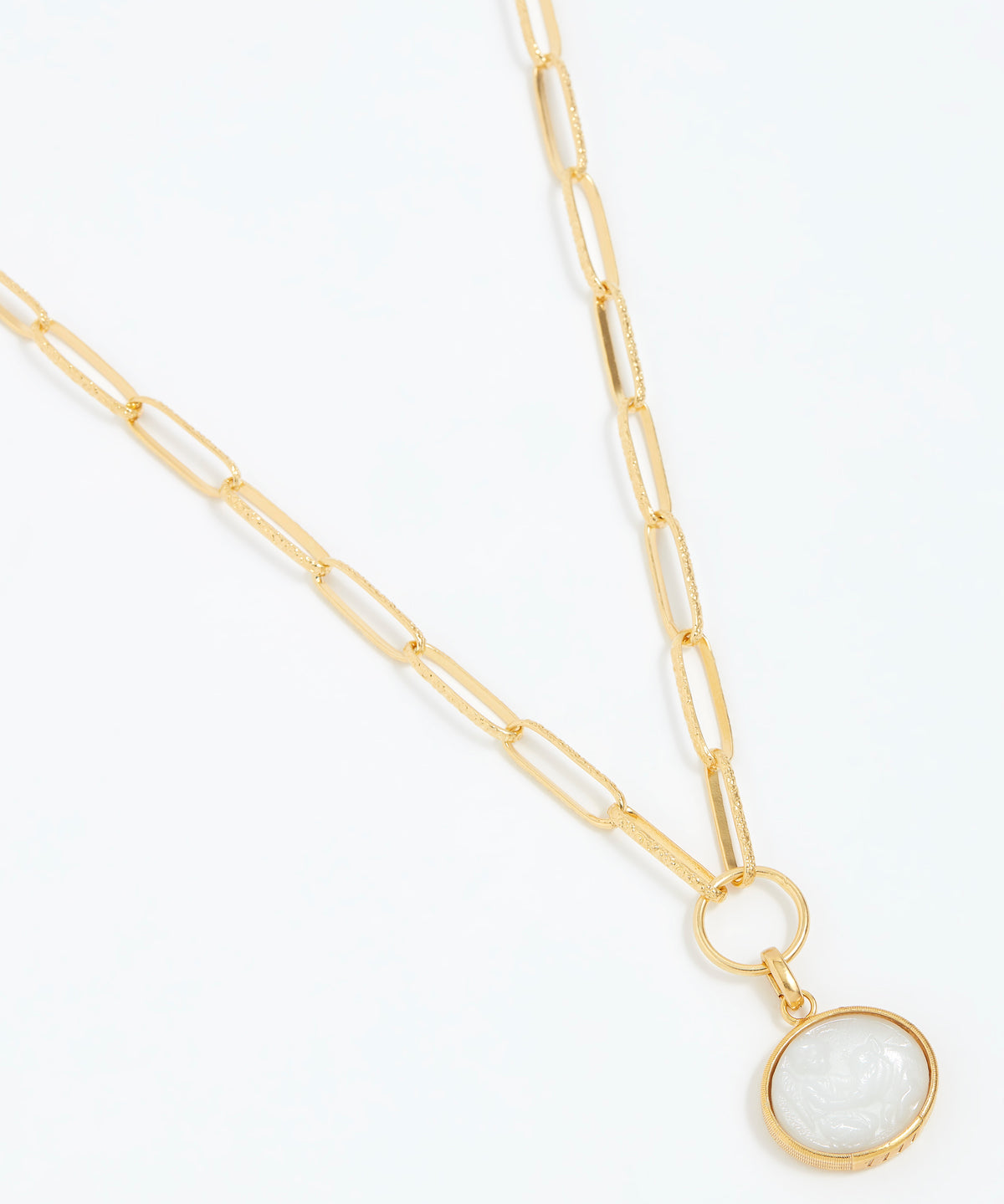 Gold necklace with a white pendant on a white background