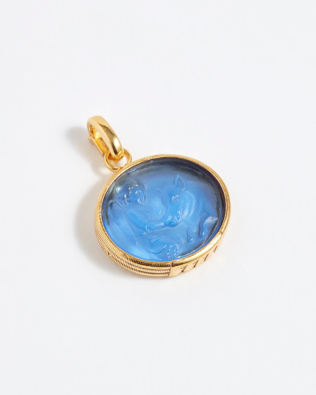 Gold pendant with blue stone on a white background