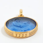 Gold pendant with blue stone and angel number '1111' engraving on a white background