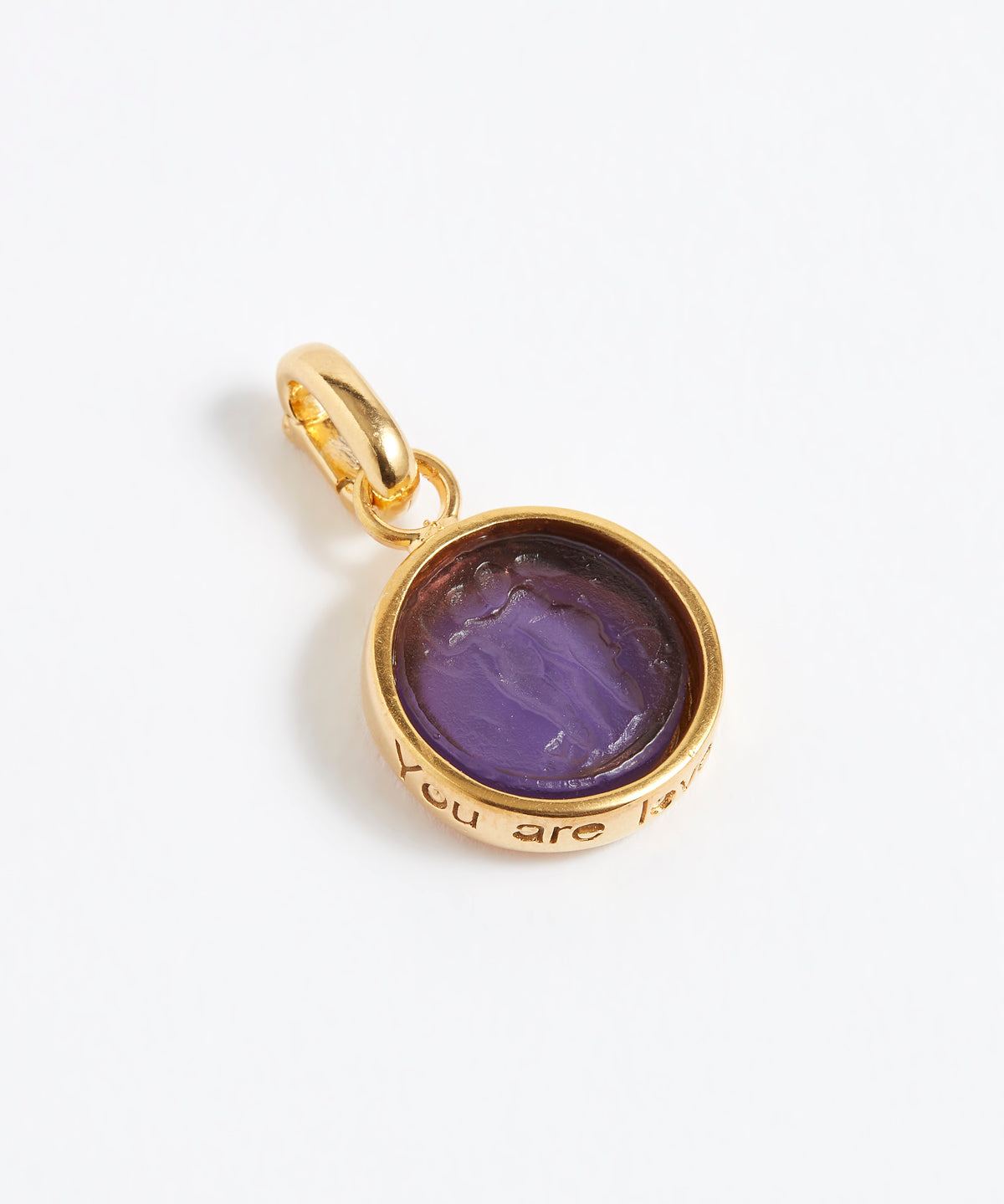 Gold pendant with purple stone on a white background