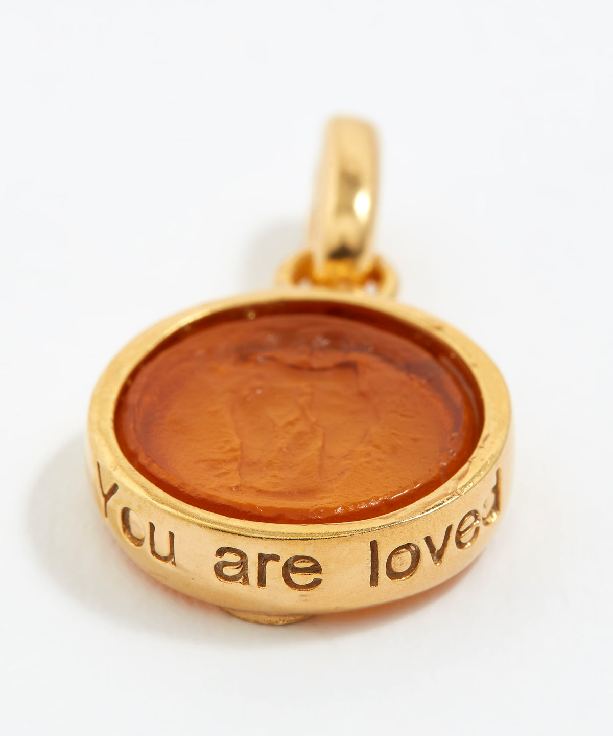 Gold pendant with brown center and 'You are loved' engraving on a white background