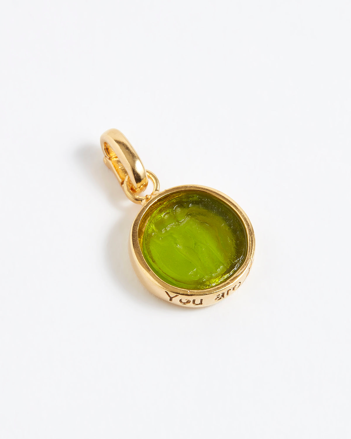 Gold pendant with a green gemstone on a white background