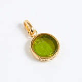 Gold pendant with a green gemstone on a white background