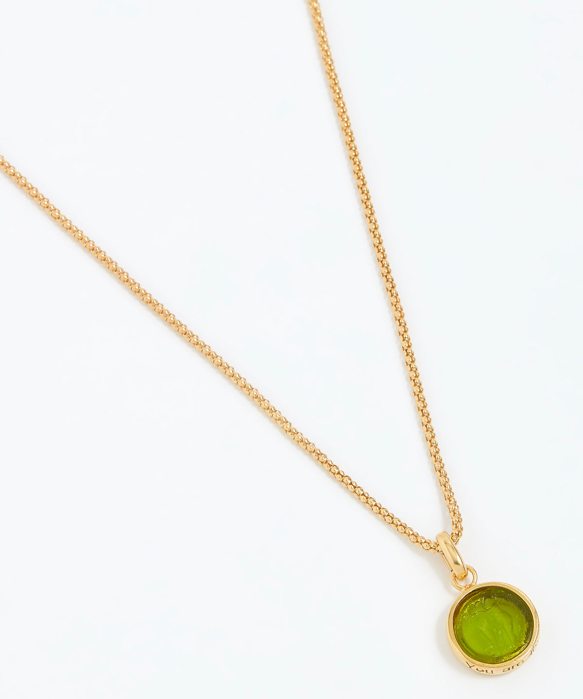 Gold necklace with a green pendant on a white background