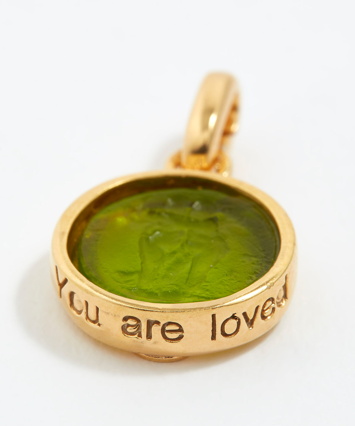 Gold pendant with green stone and 'You are loved' engraving on a white background