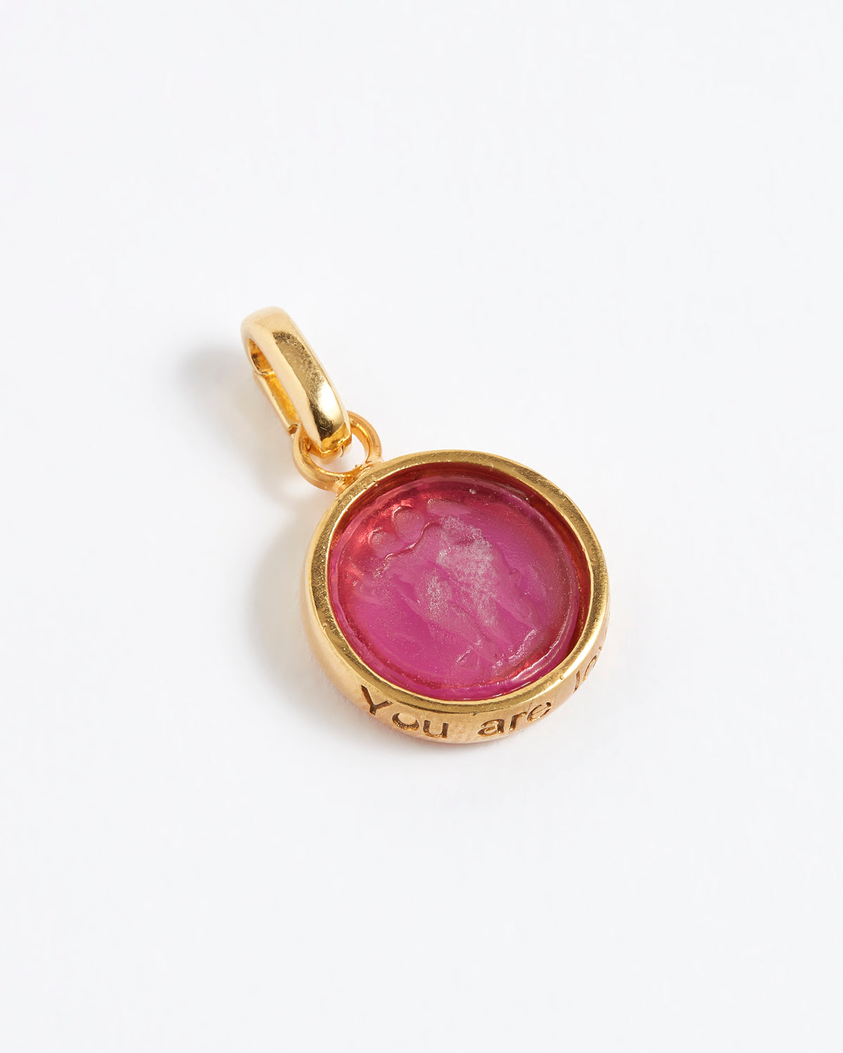 Gold pendant with a pink stone on a white background