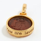 Gold pendant with a brown center and 'You are loved' engraving on a white background
