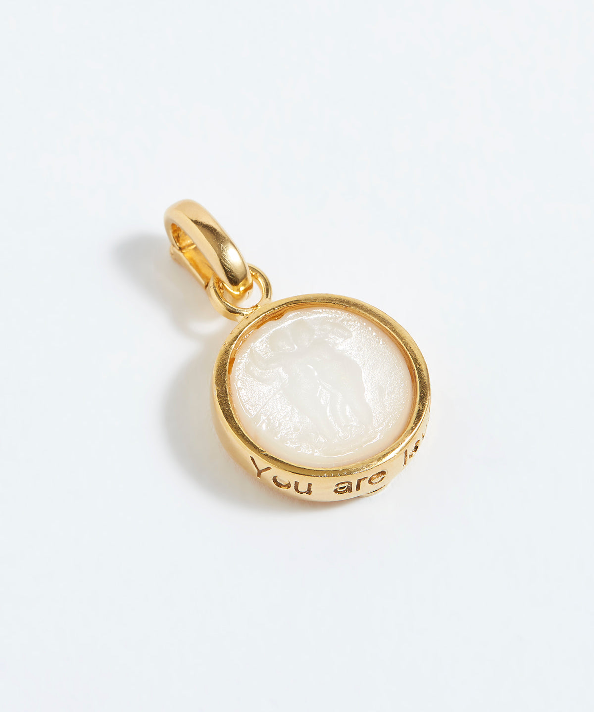 Gold pendant with a white stone on a white background