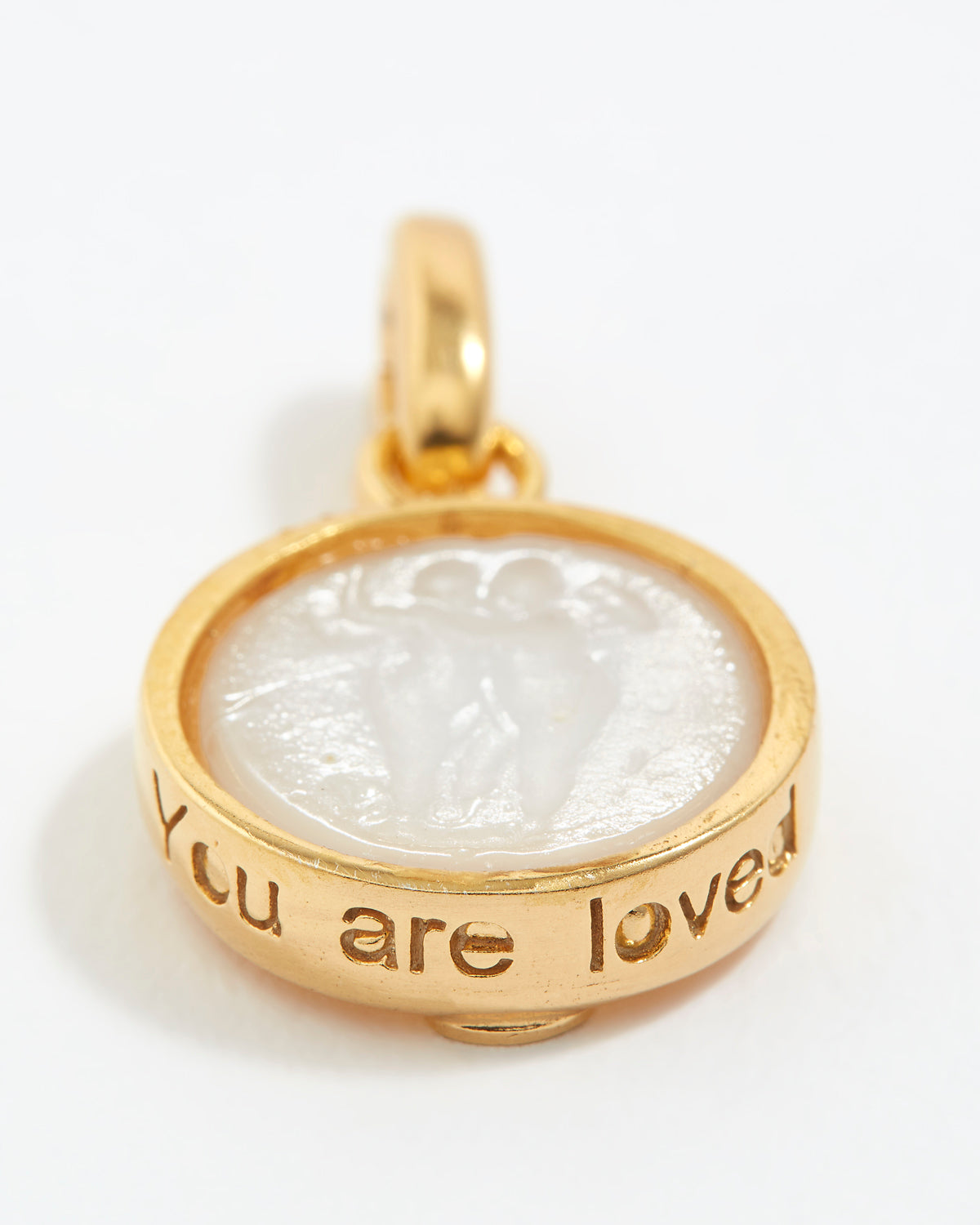Gold pendant with engraved text 'You are loved' on a white background