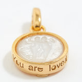 Gold pendant with engraved text 'You are loved' on a white background