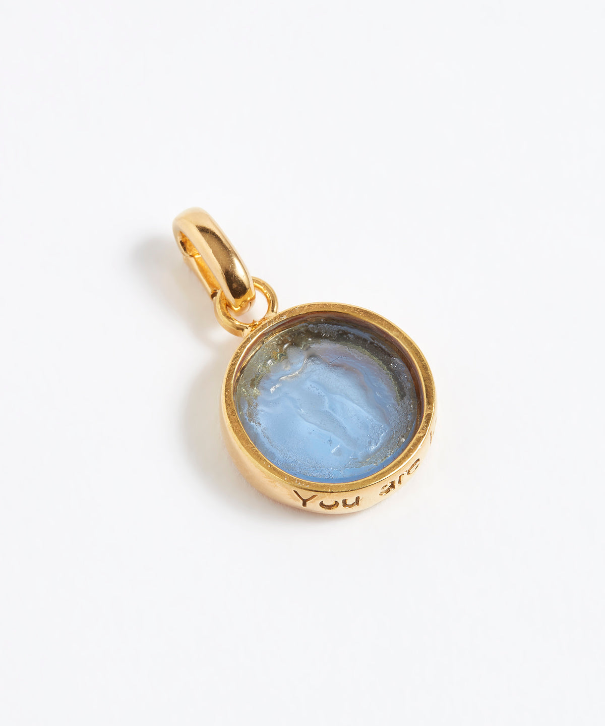 Gold pendant with a blue stone on a white background