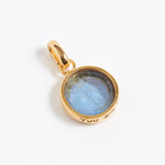 Gold pendant with a blue stone on a white background
