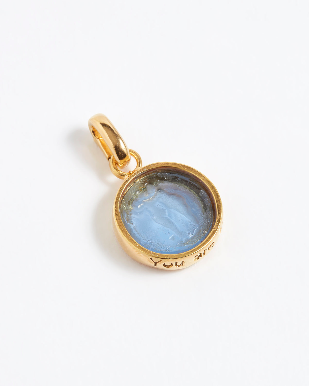 Gold pendant with a blue stone on a white background