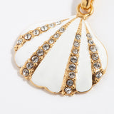 close up of gold plated silver and enamel shell charm with crystals