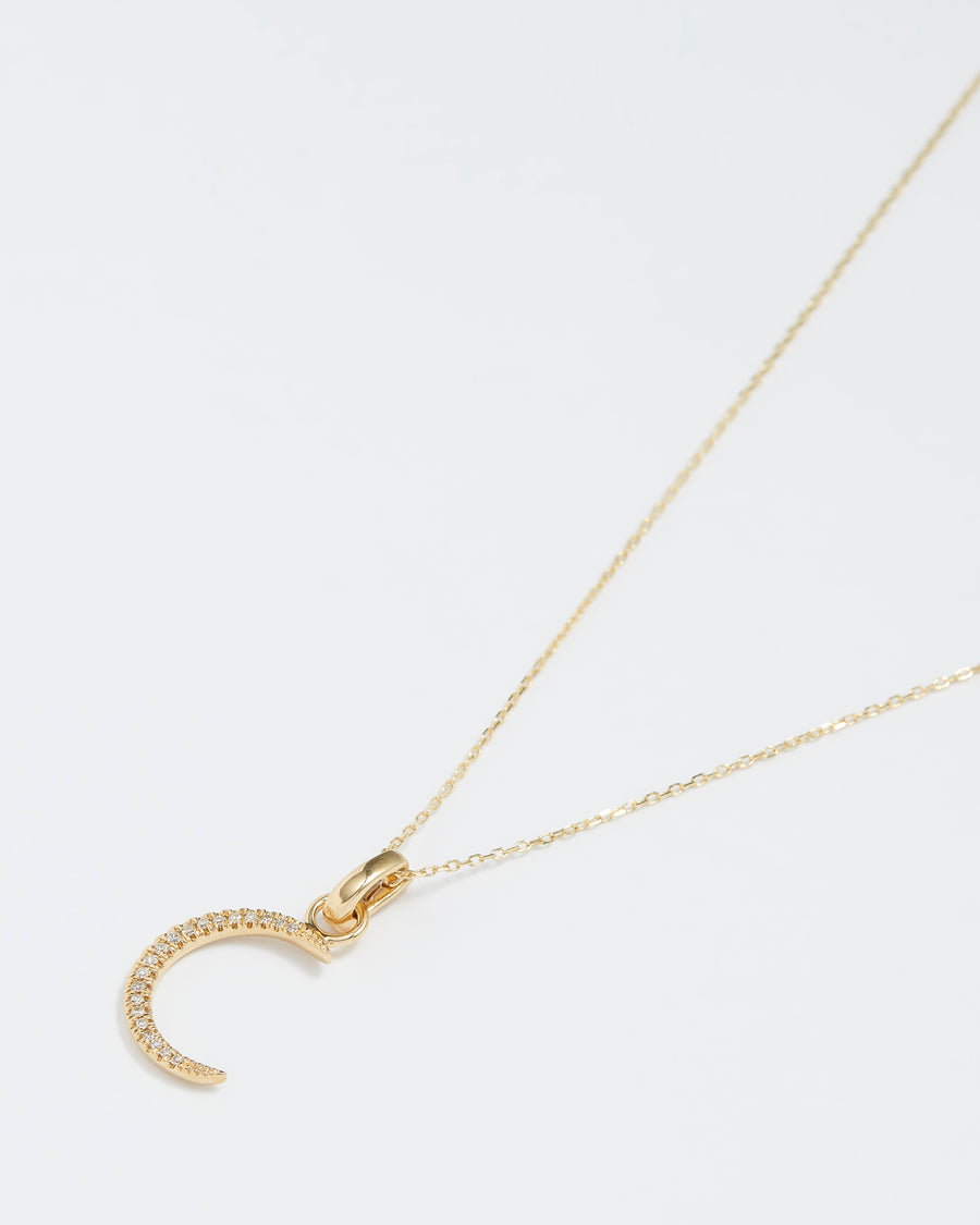 gold and diamond crescent moon charm, product shot on necklace chain