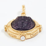 Gold pendant with purple stone engraved with wording  "Carpe Diem" and pearl on a white background