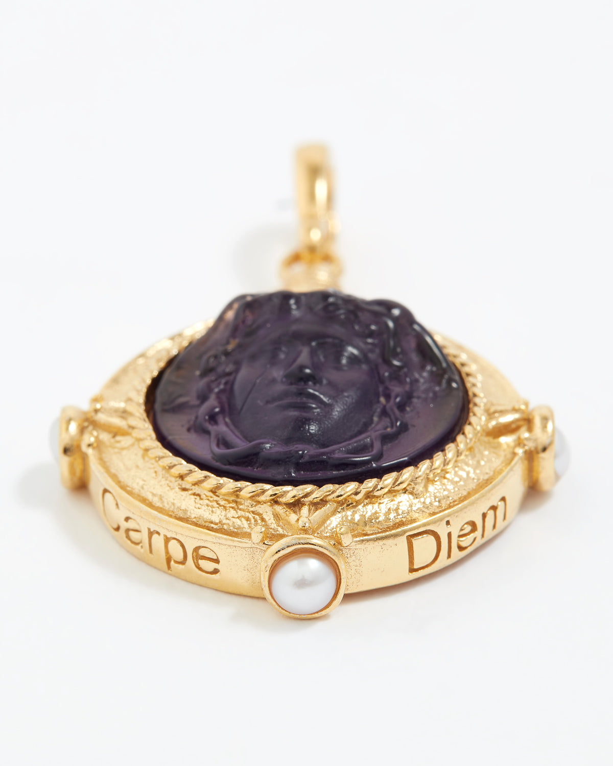 Gold pendant with purple stone engraved with wording  "Carpe Diem" and pearl on a white background