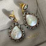 Pair of pearl earrings on a branded jewelry box
