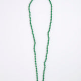 A green agate beaded necklace made of small, round, polished beads with a tiny gold spacer accent, displayed on a white background.