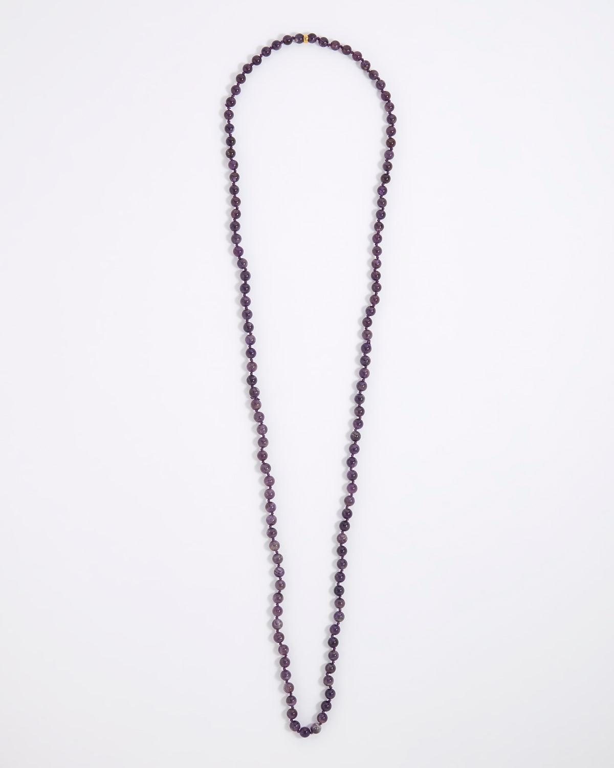 A long beaded necklace made of small dark purple faceted beads, laid flat on a plain white background.
