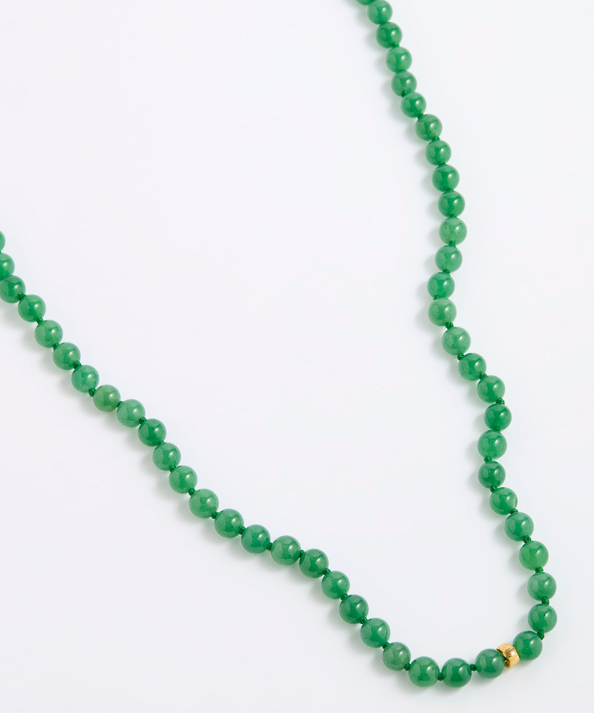 A green agate beaded necklace made of small, round, polished beads with a tiny gold spacer accent, displayed on a white background.