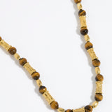 Beaded necklace with gold and tigers eye beads on white background